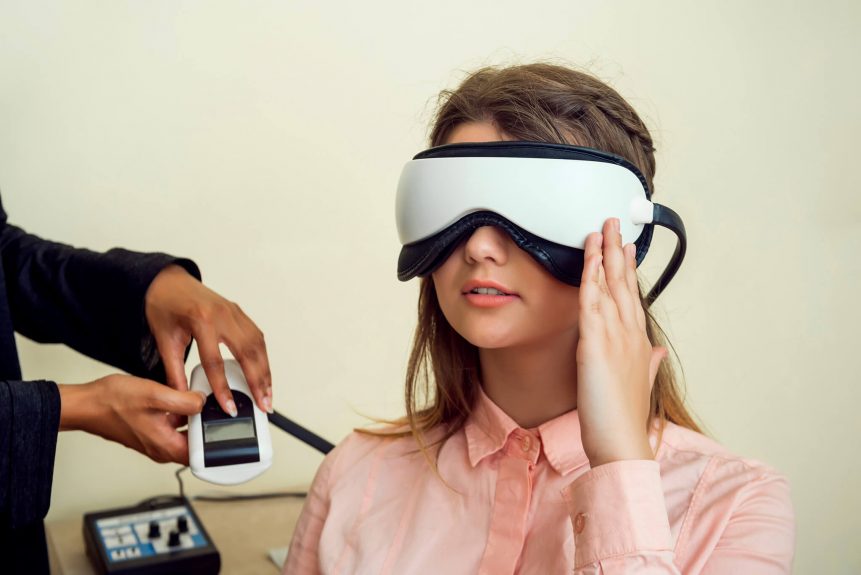 girl is worried her sight relaxed modern european woman sitting office eye care specialist waiting when procedure will be finished wearing digital vision screener during check up