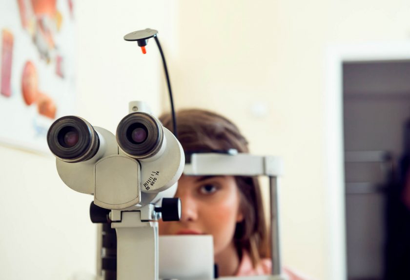 portrait cute caucasian female patient sitting optometrist office waiting start procedure check her vision with microbioscope sitting yellow wall ophthalmology concept